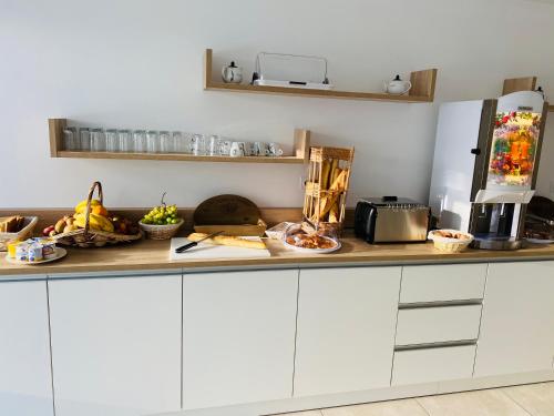 a kitchen with a counter with fruits and vegetables on it at Lagrange Apart'Hôtel Antibes Olympie in Antibes