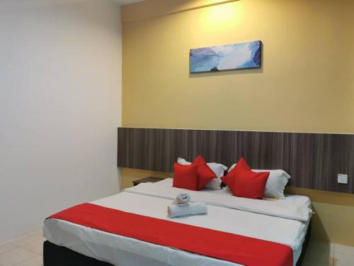 a bedroom with a large bed with red pillows at Hotel Ideal Senawang in Seremban