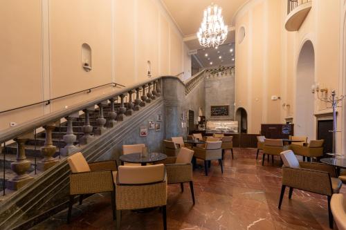 a restaurant with a staircase and tables and chairs at Star G Hotel Premium Dresden Altmarkt in Dresden