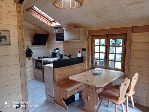 uma cozinha com uma mesa num chalé de madeira em Chalet des cascades em Le Mont-Dore