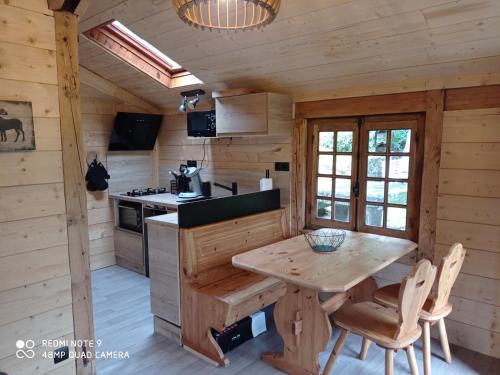 - une cuisine avec une table dans une cabane en rondins dans l'établissement Chalet des cascades, à Le Mont-Dore