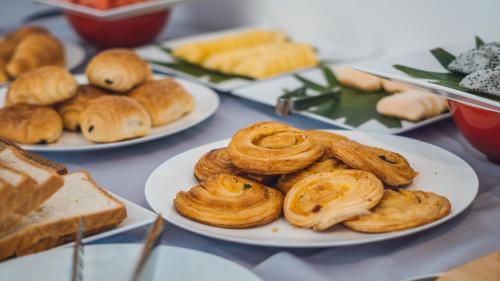 a table topped with plates of pastries and bread at Angkor Aurora in Siem Reap