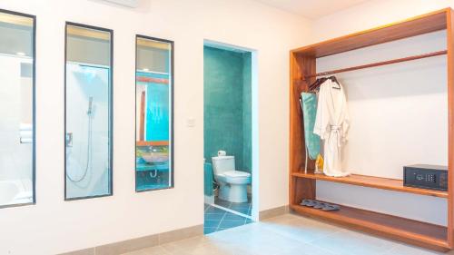 a bathroom with a toilet and a shelf and windows at Angkor Aurora in Siem Reap