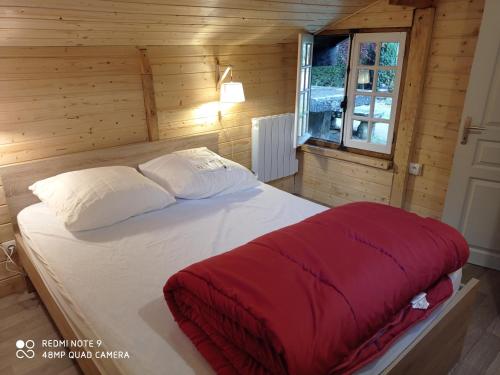 um quarto com uma cama grande num quarto de madeira em Chalet des cascades em Le Mont-Dore