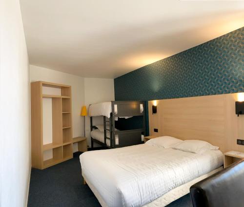 Habitación de hotel con cama y TV en Cit Hotel LA PYRAMIDE, en Romorantin-Lanthenay