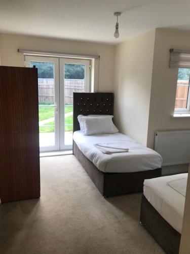 1 dormitorio con 2 camas y ventana en YBC Court, Aldershot, en Aldershot