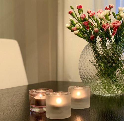 einen Tisch mit zwei Kerzen und eine Vase mit Blumen in der Unterkunft YlläStar III 606 - 2 bdrm, sauna in Äkäslompolo