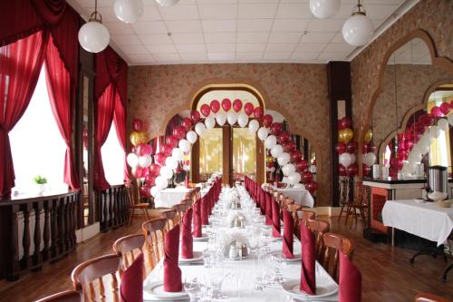 Kievskaya Hotel on Kurskaya في سانت بطرسبرغ: غرفة طعام مع طاولة طويلة مع كراسي حمراء