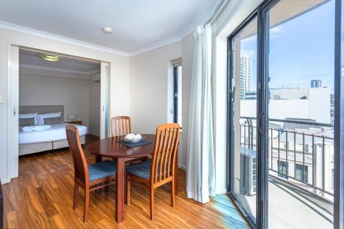 a room with a table and chairs and a bedroom at Perth West End Apartment 406 in Perth
