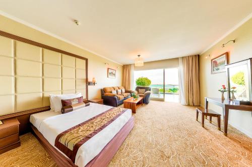 a hotel room with a bed and a living room at Sea Links Beach Hotel in Mui Ne