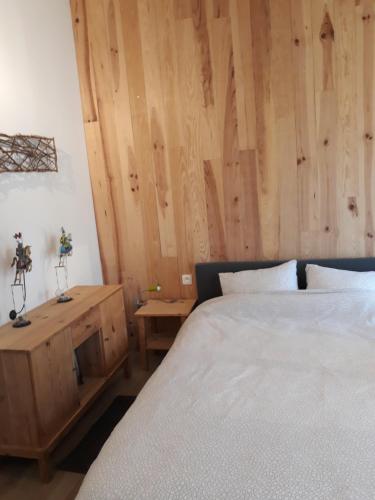a bedroom with two beds and a wooden wall at Chalet l'Orvallée in Virton