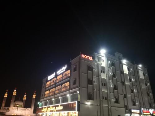 a hotel with a sign on top of it at night at Aryaf Nizwa Hotel Apartments in Nizwa