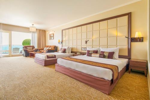 a hotel room with two beds and a living room at Sea Links Beach Hotel in Mui Ne
