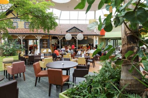 a restaurant with tables and chairs in a courtyard at Center Parcs Park De Haan in De Haan