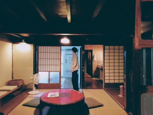 a man standing in the middle of a room at Tarachine in Ise