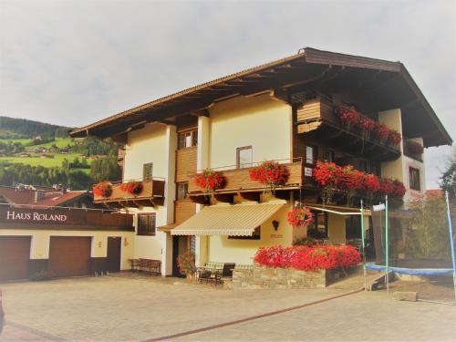 a building with flowers on the side of it at Gästehaus Roland in Kirchberg in Tirol