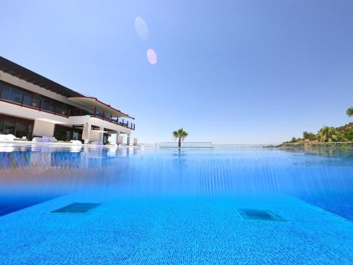 a swimming pool with blue water in front of a building at Hillstone Bodrum Hotel & Spa in Bodrum City