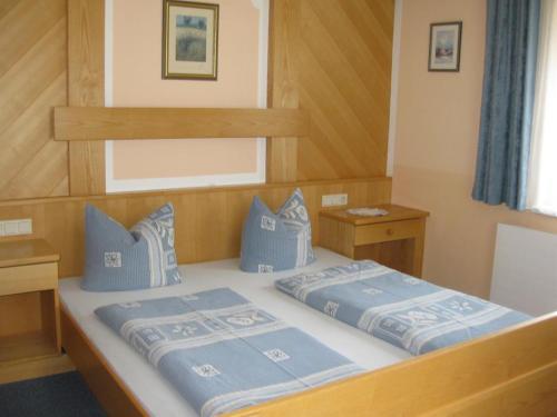 a bedroom with two beds with blue pillows at Haus Brigitta in Tux