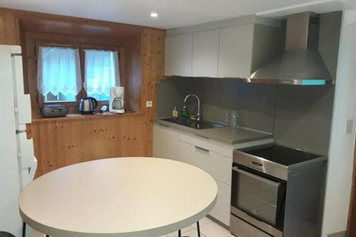 a kitchen with a white table and a white counter top at Grand Bornand-La Clusaz in Entremont