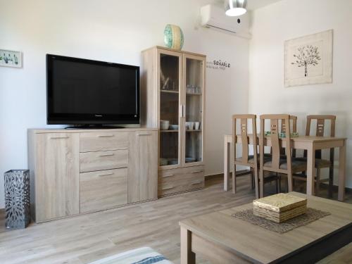 a living room with a flat screen tv on a wooden entertainment center at Apartamento Laila,Sevilla, in Alcalá de Guadaira