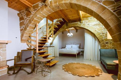 a living room with a stone wall and a spiral staircase at Villa Nicola in Kissamos