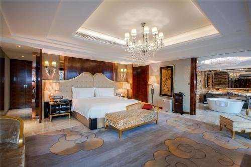 a bedroom with a bed and a bathroom with a tub at Crowne Plaza Hotel Lanzhou, an IHG Hotel in Lanzhou