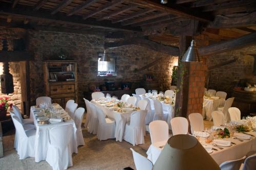 a dining room with white tables and white chairs at Apartamentos Alquitara in Potes