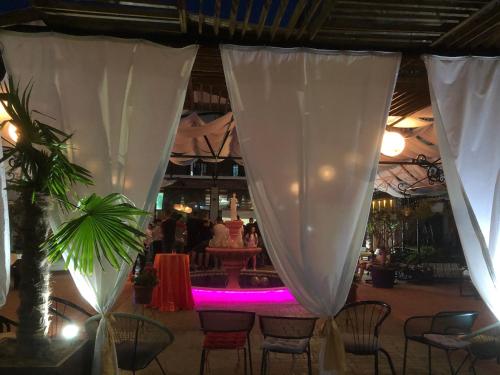 a restaurant with a table and chairs with purple lights at Hotel Internacional Gym & Spa Fushe-Arrez in Fushe-Arrez