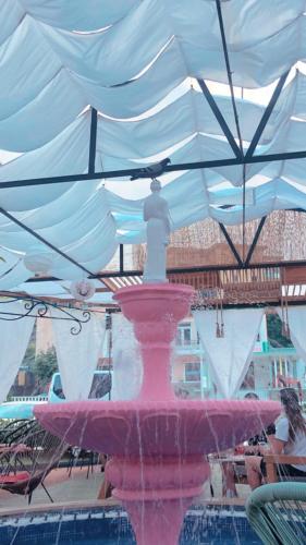 a pink fountain under a white umbrella at Hotel Internacional Gym & Spa Fushe-Arrez in Fushe-Arrez