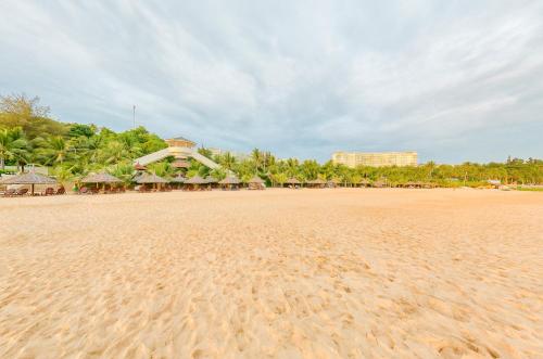 a sandy beach with a resort in the background at Sea Links Beach Hotel in Mui Ne