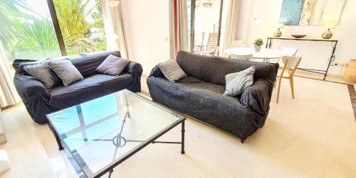 sala de estar con 2 sofás y mesa de cristal en SKOL 233. Wonderful Two Bedroom Apartment in Marbella Center., en Marbella