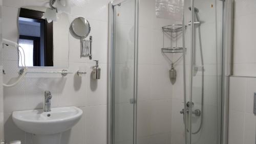 een badkamer met een wastafel en een glazen douche bij Kucuk Velic Hotel in Gaziantep