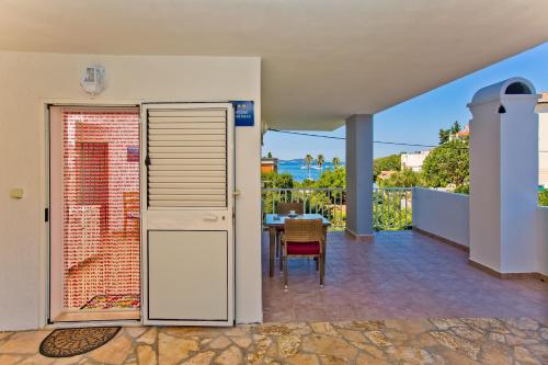 een huis met een patio met een tafel en een balkon bij Apartments Hruban in Hvar