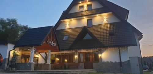 a house with a gambrel roof with lights on it at Na Kamieńcu in Czarny Dunajec