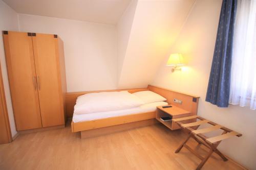 a small bedroom with a bed and a desk at Gasthof Lamm in Beilstein