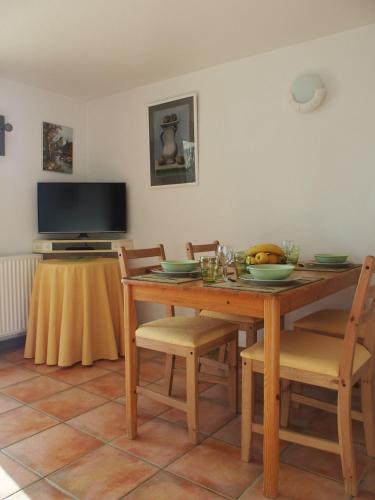 une salle à manger avec une table en bois, des chaises et une télévision dans l'établissement Au Bouillat d Anty, à Châtel-Guyon
