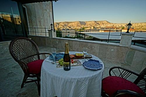 a table with a bottle of champagne and food on it at Balloon Cave Hotel in Goreme