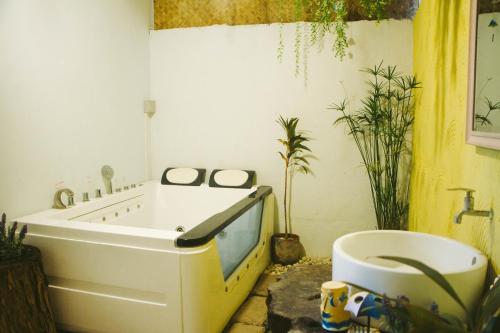 a bathroom with a tub and a toilet in it at Terrua Main Ten Villa Garden in Suan Phung