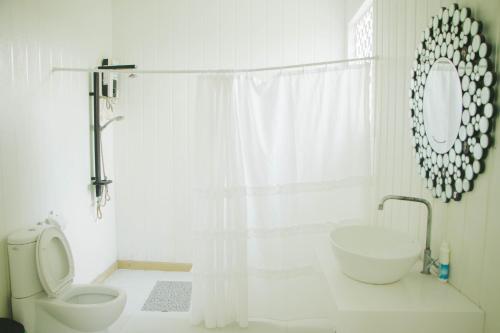 a white bathroom with a toilet and a sink at Terrua Main Ten Villa Garden in Suan Phung