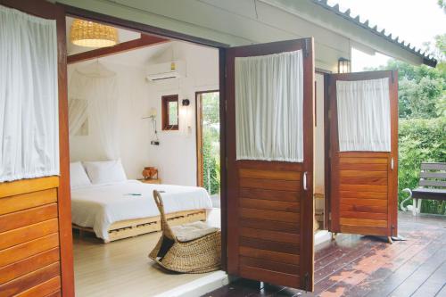 a bedroom with a bed and a bed and sliding doors at Terrua Main Ten Villa Garden in Suan Phung