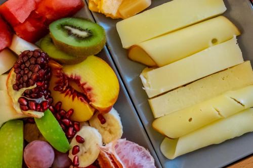 a plate of different types of cheese and fruit at Central Fira Suites in Fira