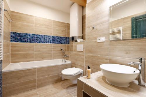 La salle de bains est pourvue d'un lavabo, de toilettes et d'une baignoire. dans l'établissement Apartmány pod Mariánskými schody, à Desná