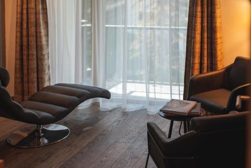 a living room with two chairs and a window at Joe's Place - luxury lifestyle apartment in Zermatt