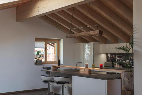 a kitchen with a black counter and stools at Joe's Place - luxury lifestyle apartment in Zermatt
