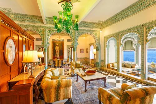 a living room filled with furniture and a chandelier at Shiv Niwas Palace by HRH Group of Hotels in Udaipur