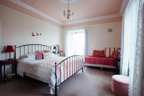 a bedroom with a bed and a red chair at Tom Blake House in Kells
