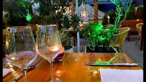 two wine glasses sitting on a wooden table at Hotel Calasanz in Molins de Rei