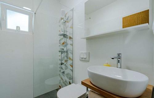 a white bathroom with a sink and a shower at Beachfront Villa Tempera with Seaview in Blato