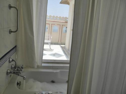 a bathroom with a tub and a window with a view at Shiv Niwas Palace by HRH Group of Hotels in Udaipur