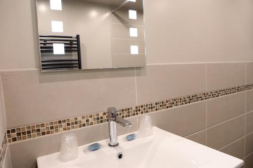 a bathroom with a sink and a mirror at Le Domaine Du Lieu Athan ,réservé aux adultes in Saint-Gâtien-des-Bois